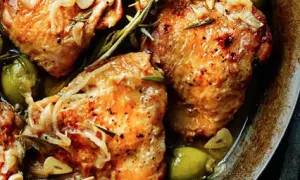 Juicy chicken tapa with olives, garlic, and rosemary, seasoned with pepper and herbs, served in a rustic dish.