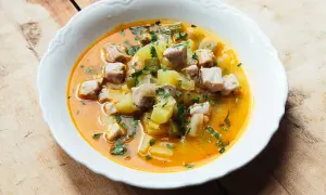 A hearty bowl of marmitako recipe, featuring tender tuna chunks, potatoes, and peppers in a rich, savory broth, garnished with fresh parsley.