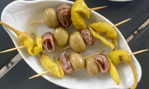 A classic gilda food tapa: skewers with green olives, anchovies, and pickled peppers.