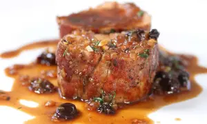 Succulent Iberico pork shoulder recipe, seared and glazed with a rich sauce and studded with dried fruit.