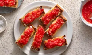 A plate of pan con tomate, toasted bread slices topped with fresh, grated tomatoes and sea salt.