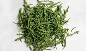 A pile of fresh, bright green sea beans, also known as samphire, ready to be seasoned and enjoyed.