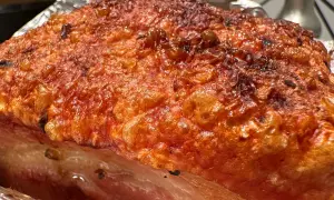 Crispy, golden-brown crackling on a succulent Iberico pork belly recipe, ready to be carved.
