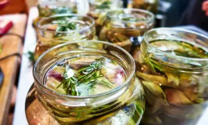 Jars filled with pickled artichoke hearts and rosemary sprigs, ready for a delicious meal.