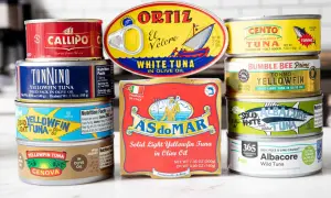 A colorful assortment of canned tuna food, featuring brands like Ortiz, Cento, Bumble Bee, and Genova, showcasing various types of tuna in olive oil.