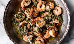 A close-up of a pan filled with succulent shrimp, glistening in a flavorful herb and garlic sauce. These are perfect for quick and delicious shrimp recipes.