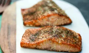 Two seasoned salmon fillets, ready to be smoked. Learn how to smoke salmon in an electric smoker for a delicious meal.