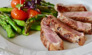 Juicy iberico pork chop recipe served with roasted asparagus and cherry tomatoes.