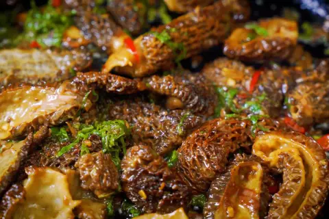 Sautéed morel mushrooms with herbs and chili, showcasing the best way to cook morel mushrooms for a delicious meal.
