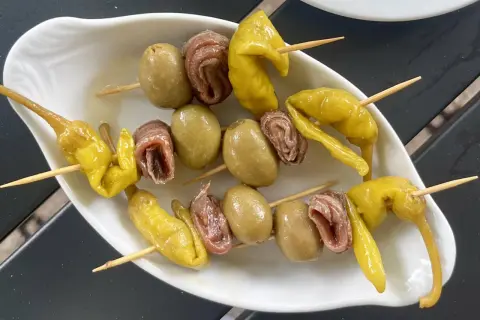 A classic gilda food tapa: skewers with green olives, anchovies, and pickled peppers.