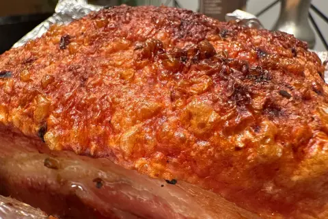 Crispy, golden-brown crackling on a succulent Iberico pork belly recipe, ready to be carved.