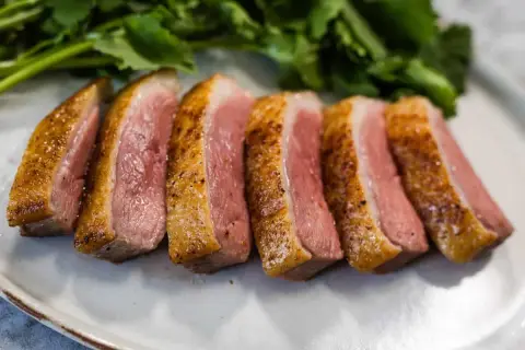 Perfectly seared duck breast, sliced and ready to serve. This duck breast recipe yields tender, juicy meat with a crispy skin.