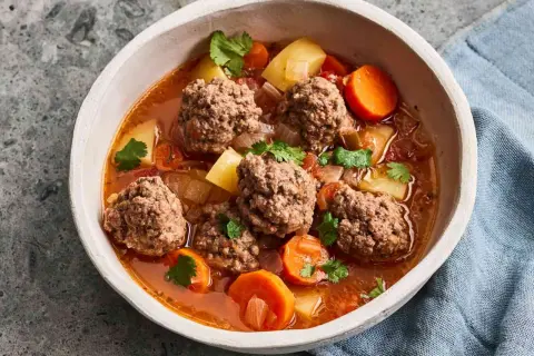 Hearty albondigas soup from Spain, with tender meatballs, potatoes, carrots, and cilantro in a rich broth.