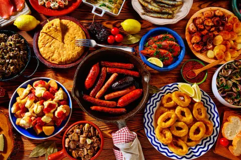 A vibrant spread of Spanish tapas: fried calamari, grilled sardines, chorizo, patatas bravas, and more. These small plates are perfect for sharing!