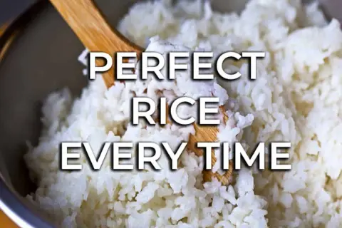 Fluffy white rice being stirred with a wooden spoon. Learn how to cook rice perfectly every time for delicious meals.