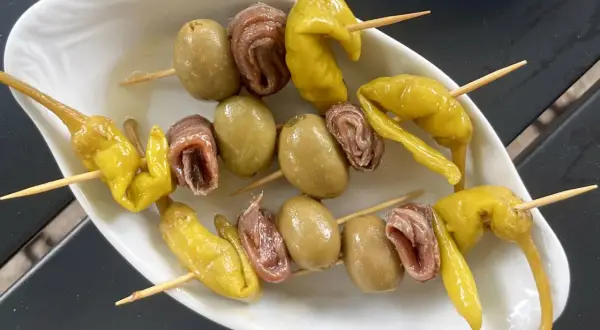 A classic gilda food tapa: skewers with green olives, anchovies, and pickled peppers.