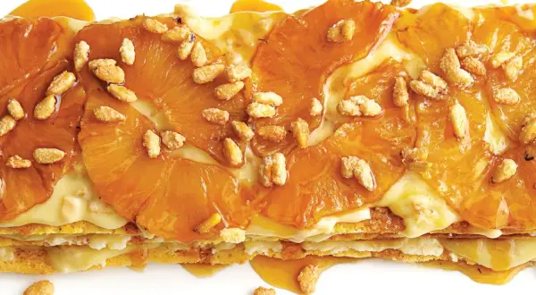 A layered dessert with caramelized pineapple slices and a creamy filling, sprinkled with toasted pine nuts. A delicious addition to pine nut recipes.