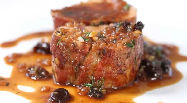 Succulent Iberico pork shoulder recipe, seared and glazed with a rich sauce and studded with dried fruit.