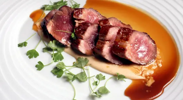 Perfectly seared Iberico pork slices, glistening with sauce and garnished with fresh parsley. This dish showcases how to cook Iberico pork to tender perfection.