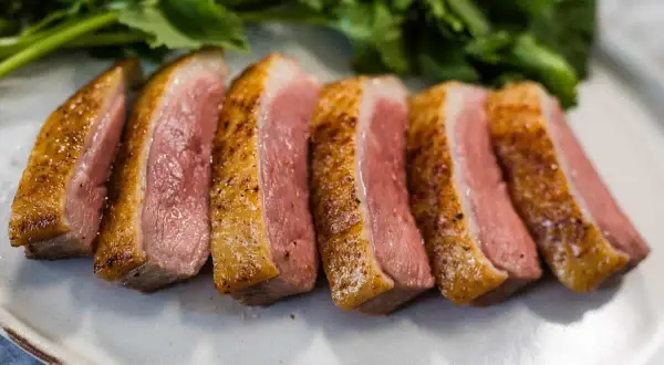 Perfectly seared duck breast, sliced and ready to serve. This duck breast recipe yields tender, juicy meat with a crispy skin.