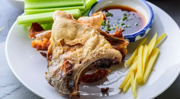 Crispy fried fish collar served with celery sticks, ginger matchsticks, and a dipping sauce. A delicious fish collar recipe.