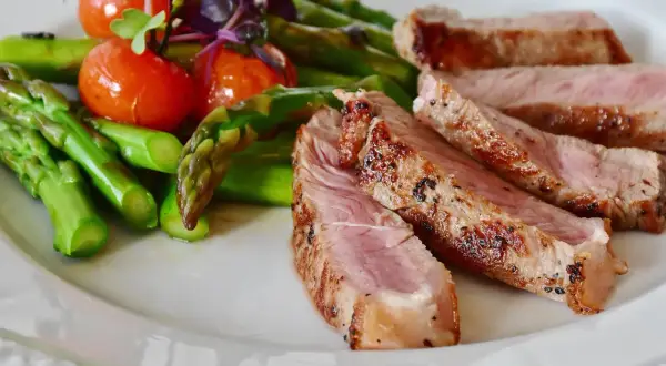 Juicy iberico pork chop recipe served with roasted asparagus and cherry tomatoes.