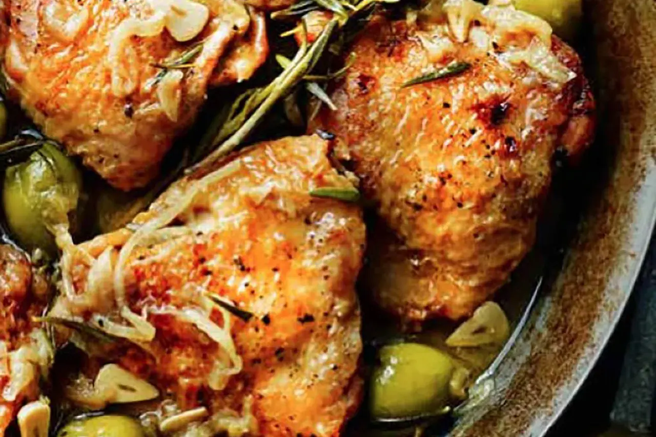 Juicy chicken tapa with olives, garlic, and rosemary, seasoned with pepper and herbs, served in a rustic dish.