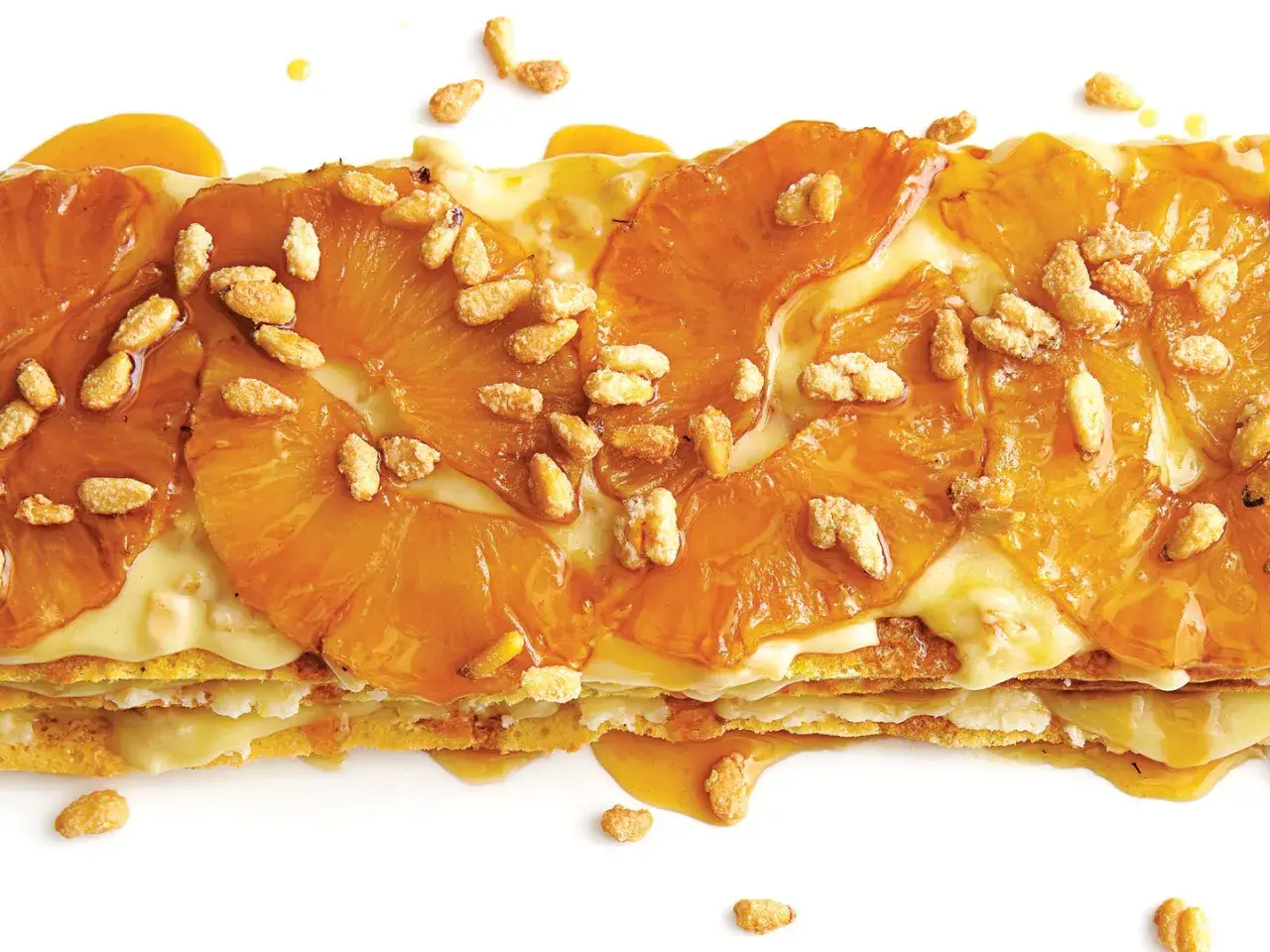 A layered dessert with caramelized pineapple slices and a creamy filling, sprinkled with toasted pine nuts. A delicious addition to pine nut recipes.
