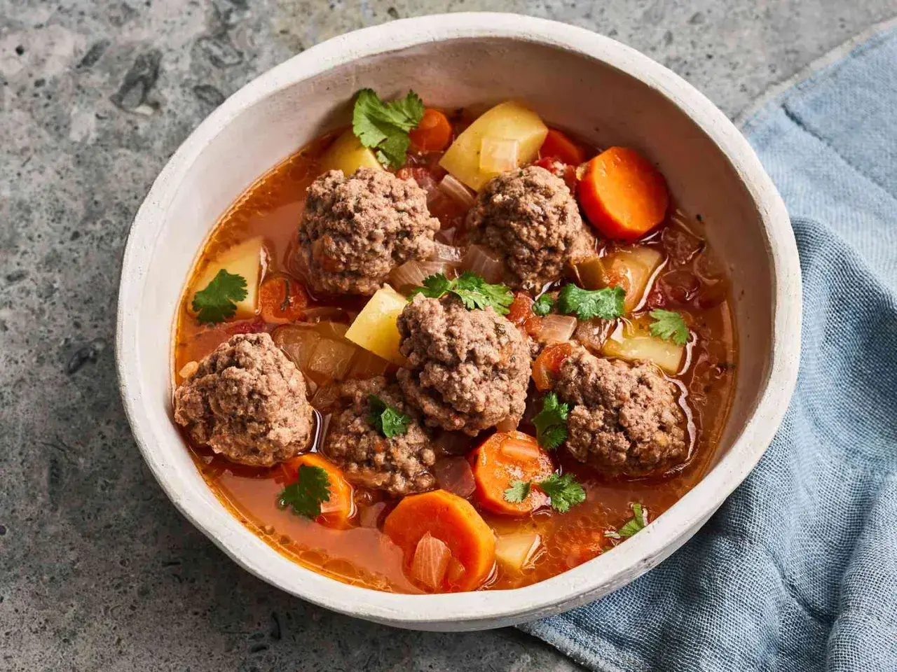 Hearty albondigas soup from Spain, with tender meatballs, potatoes, carrots, and cilantro in a rich broth.