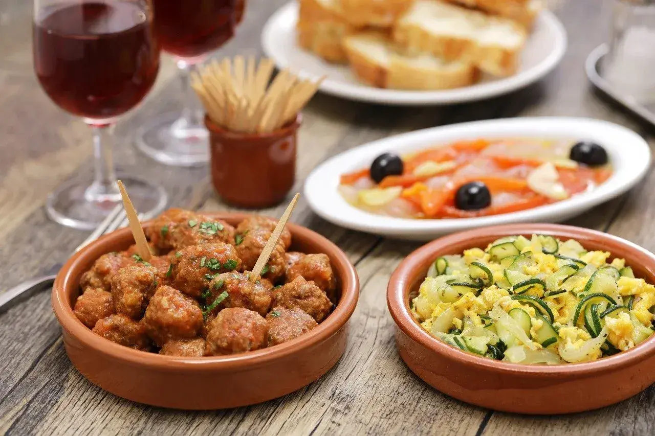 A delicious spread of albondigas españolas, tapas, and wine, perfect for a Spanish feast.