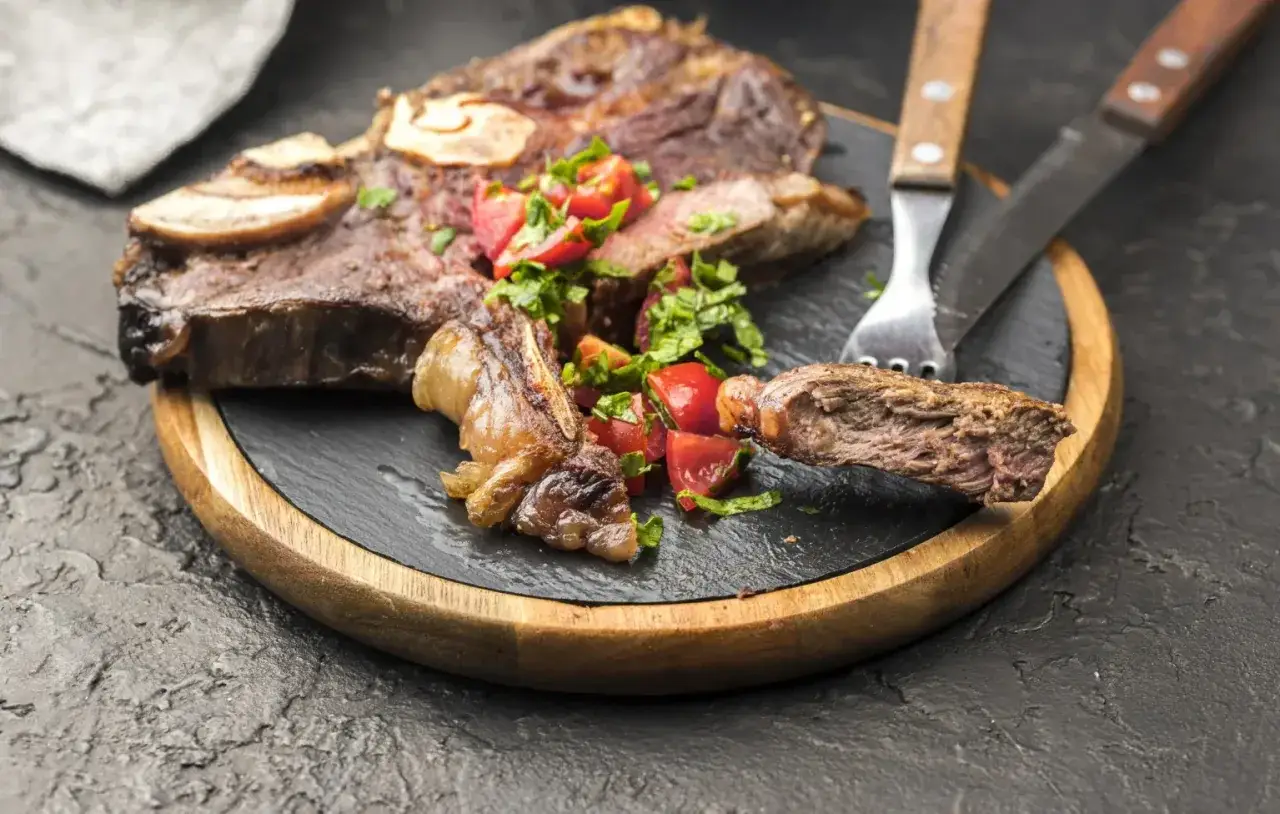 A juicy, bone-in steak, a classic among Spanish beef dishes, served with fresh tomato and parsley salad.