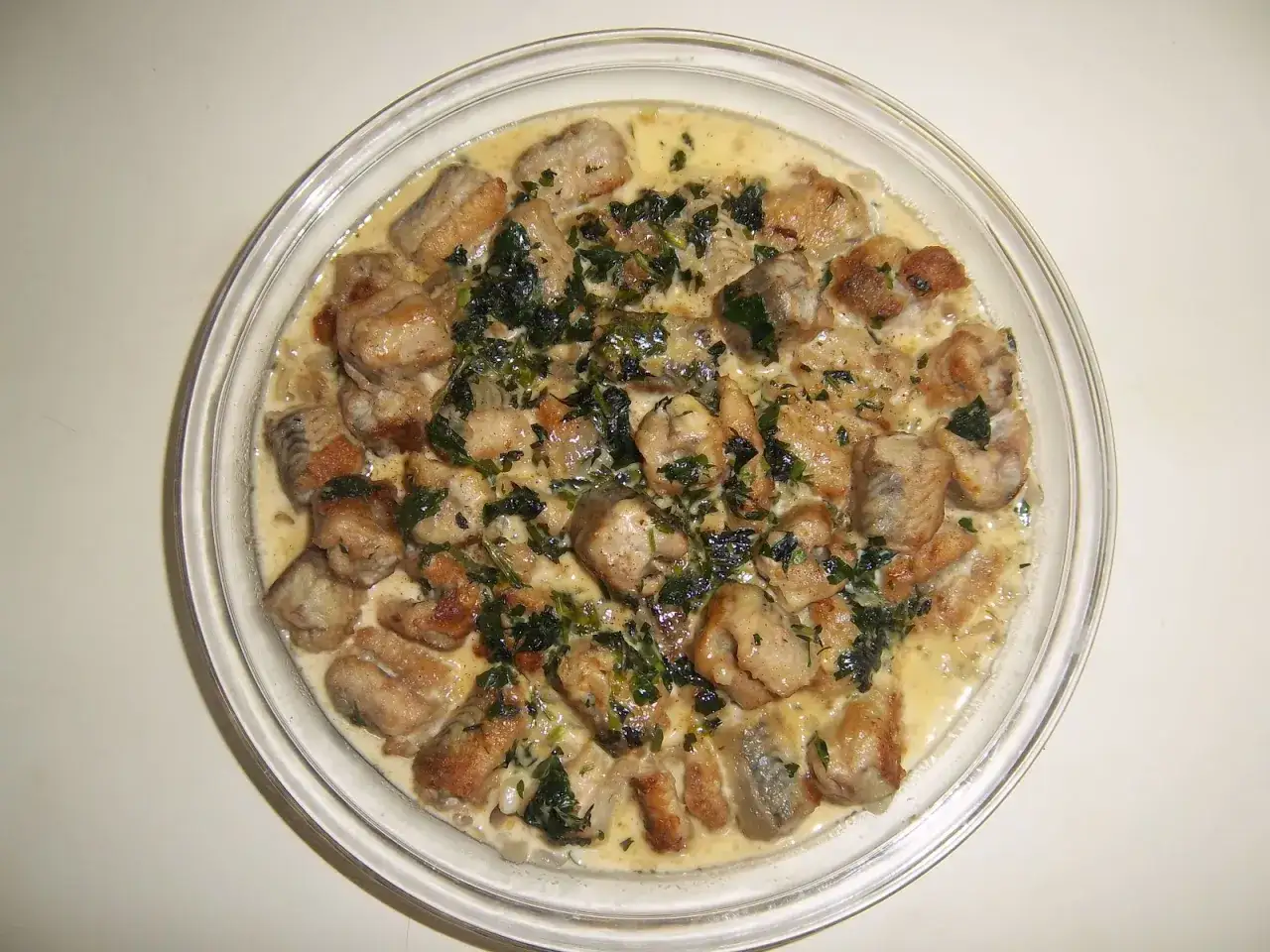 A creamy dish of pan-fried eel pieces, garnished with fresh herbs. A delicious addition to your eel recipes collection.