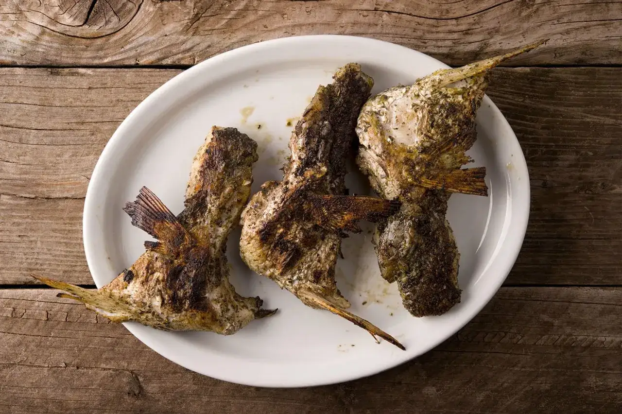 Grilled fish collars seasoned with herbs, ready for a delicious fish collar recipe.