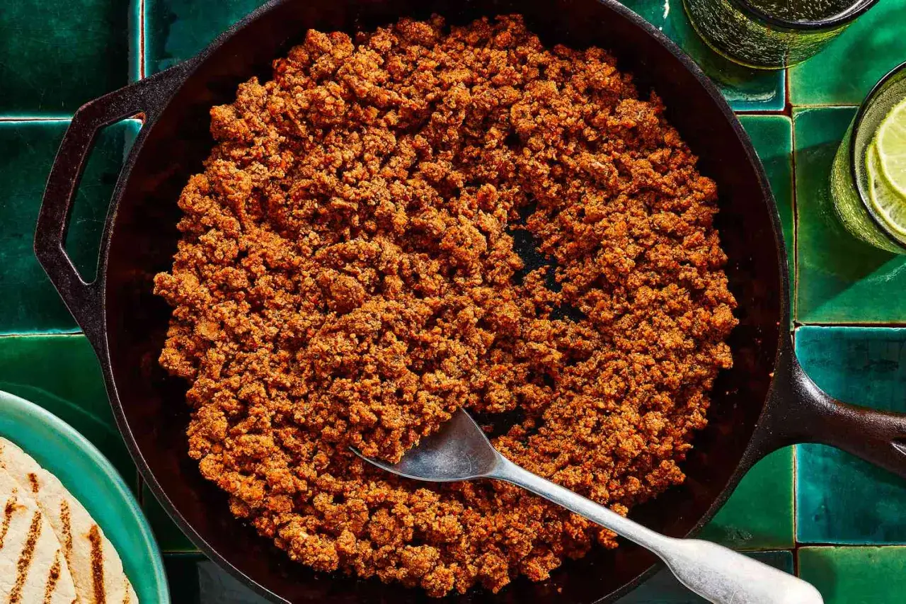 A cast-iron skillet filled with perfectly sauteed chorizo, ready to be served with warm tortillas and refreshing lime-infused drinks.