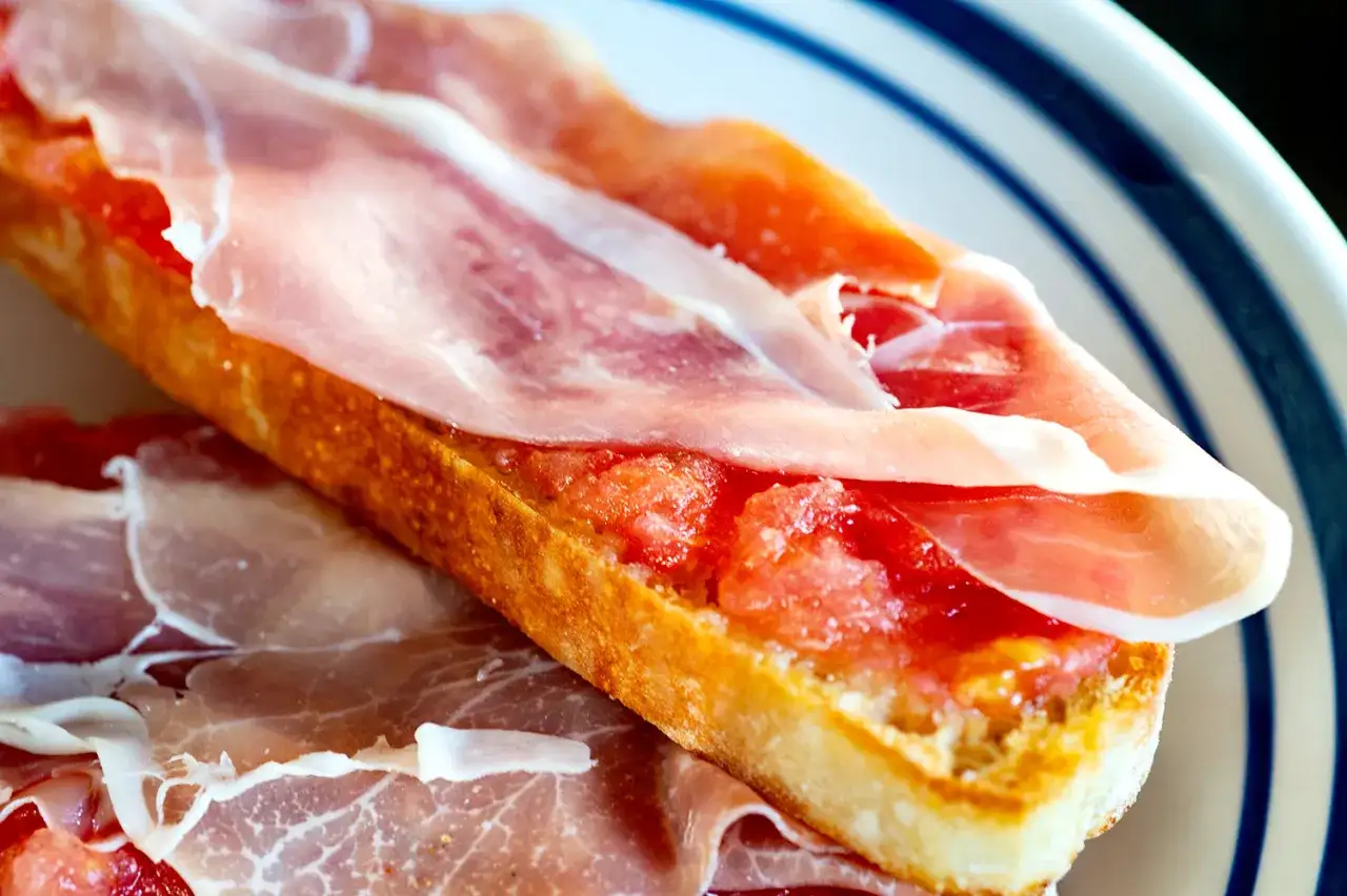 A delicious bocadillo de jamon, with thinly sliced cured ham atop grated tomato on toasted bread.