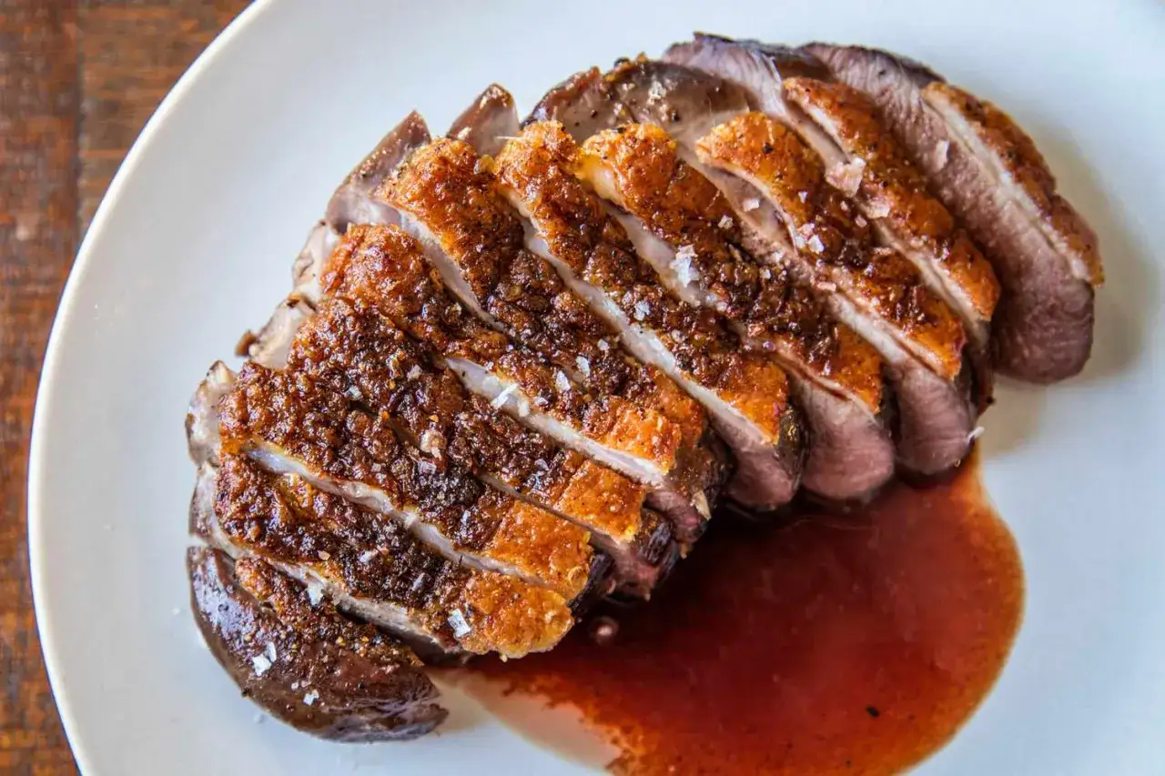 Perfectly seared duck breast, sliced and glistening with a rich sauce. This duck breast recipe looks delicious!