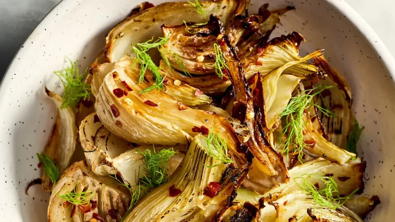 Roasted fennel wedges, seasoned with chili flakes and fresh dill, perfect for simple fennel recipes.