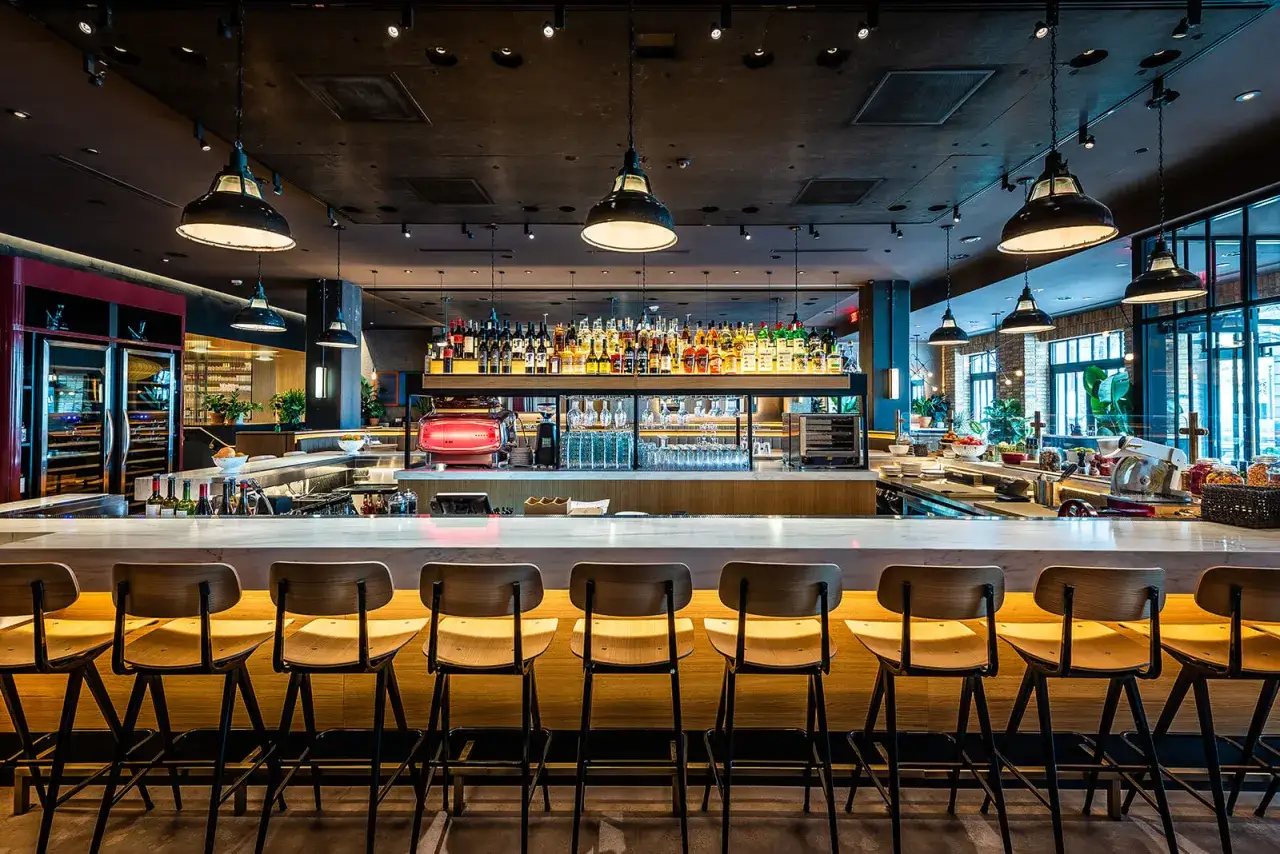 A modern bar with rows of stools and a well-stocked liquor shelf. Imagine enjoying delicious tapas here with friends.