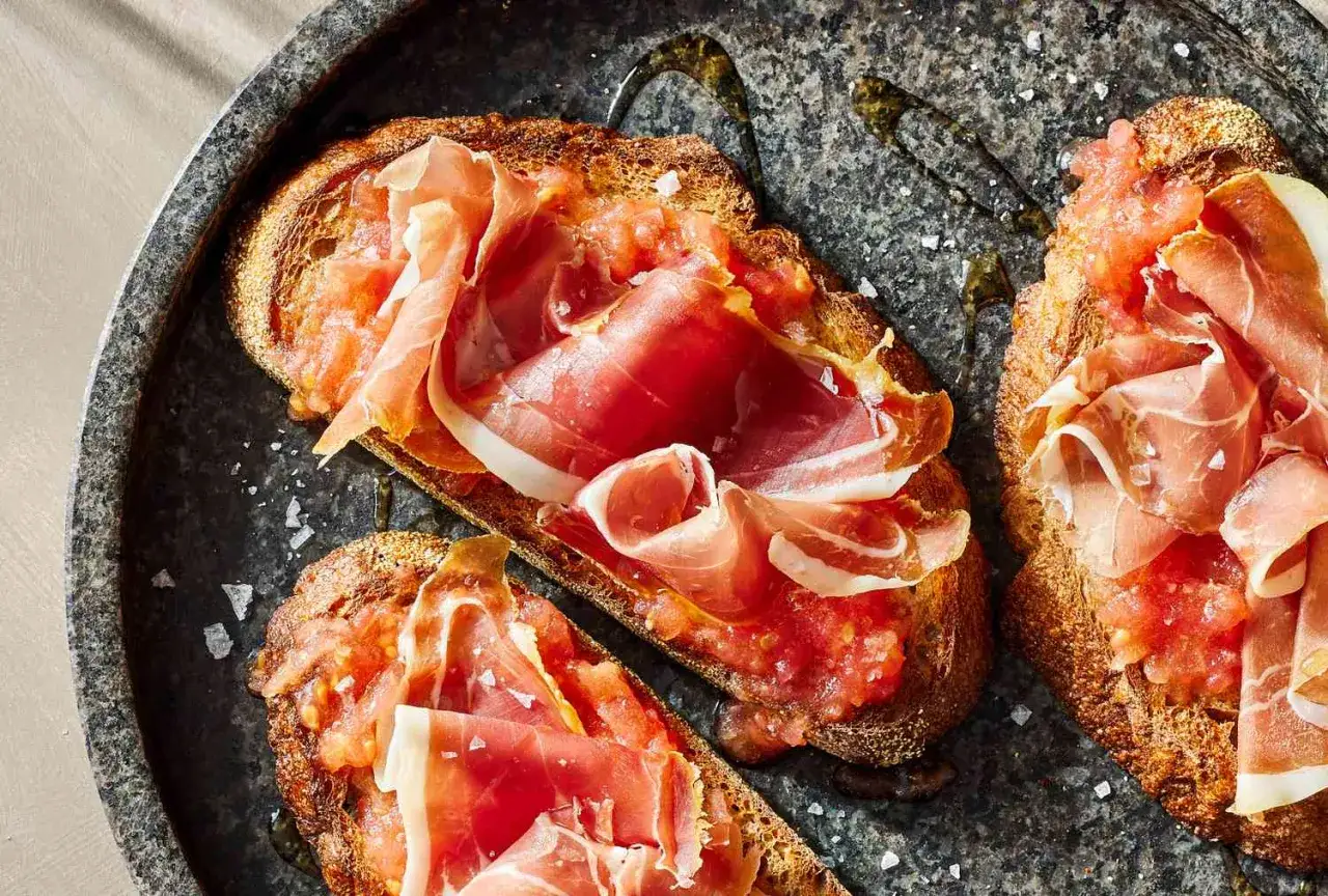 Toasted bread topped with grated tomato and thin slices of jamon Iberico, drizzled with olive oil.
