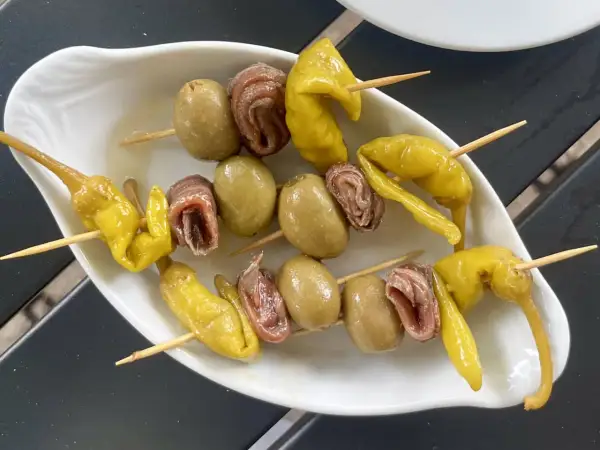 A classic gilda food tapa: skewers with green olives, anchovies, and pickled peppers.