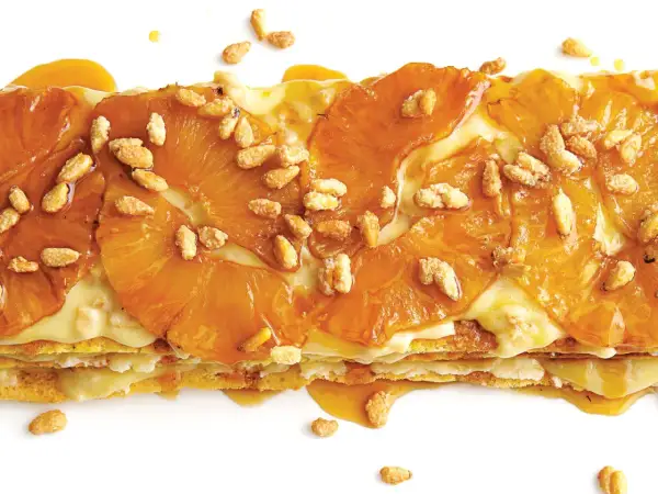 A layered dessert with caramelized pineapple slices and a creamy filling, sprinkled with toasted pine nuts. A delicious addition to pine nut recipes.