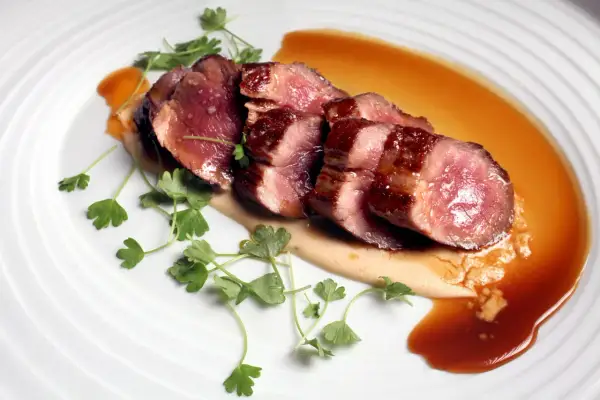 Perfectly seared Iberico pork slices, glistening with sauce and garnished with fresh parsley. This dish showcases how to cook Iberico pork to tender perfection.