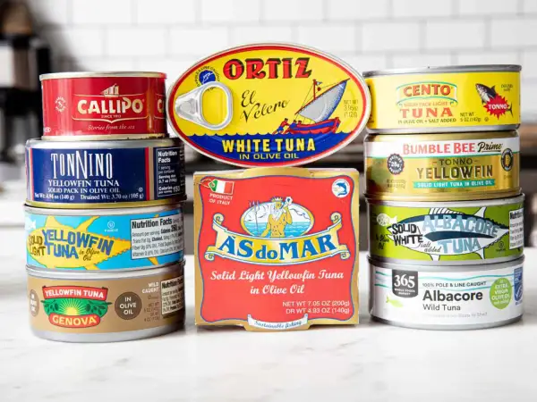 A colorful assortment of canned tuna food, featuring brands like Ortiz, Cento, Bumble Bee, and Genova, showcasing various types of tuna in olive oil.