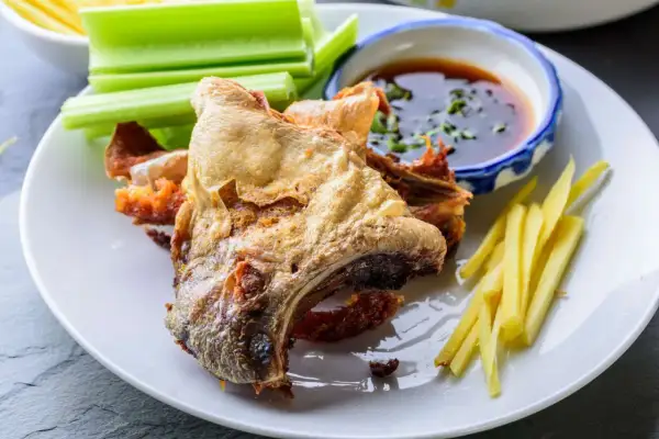 Crispy fried fish collar served with celery sticks, ginger matchsticks, and a dipping sauce. A delicious fish collar recipe.