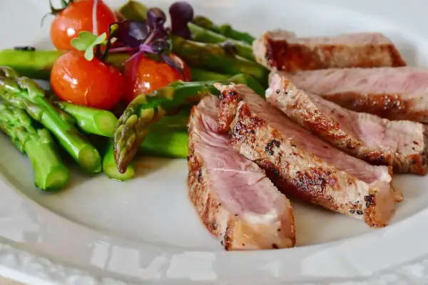 Juicy iberico pork chop recipe served with roasted asparagus and cherry tomatoes.