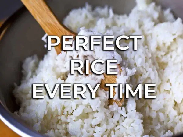 Fluffy white rice being stirred with a wooden spoon. Learn how to cook rice perfectly every time for delicious meals.